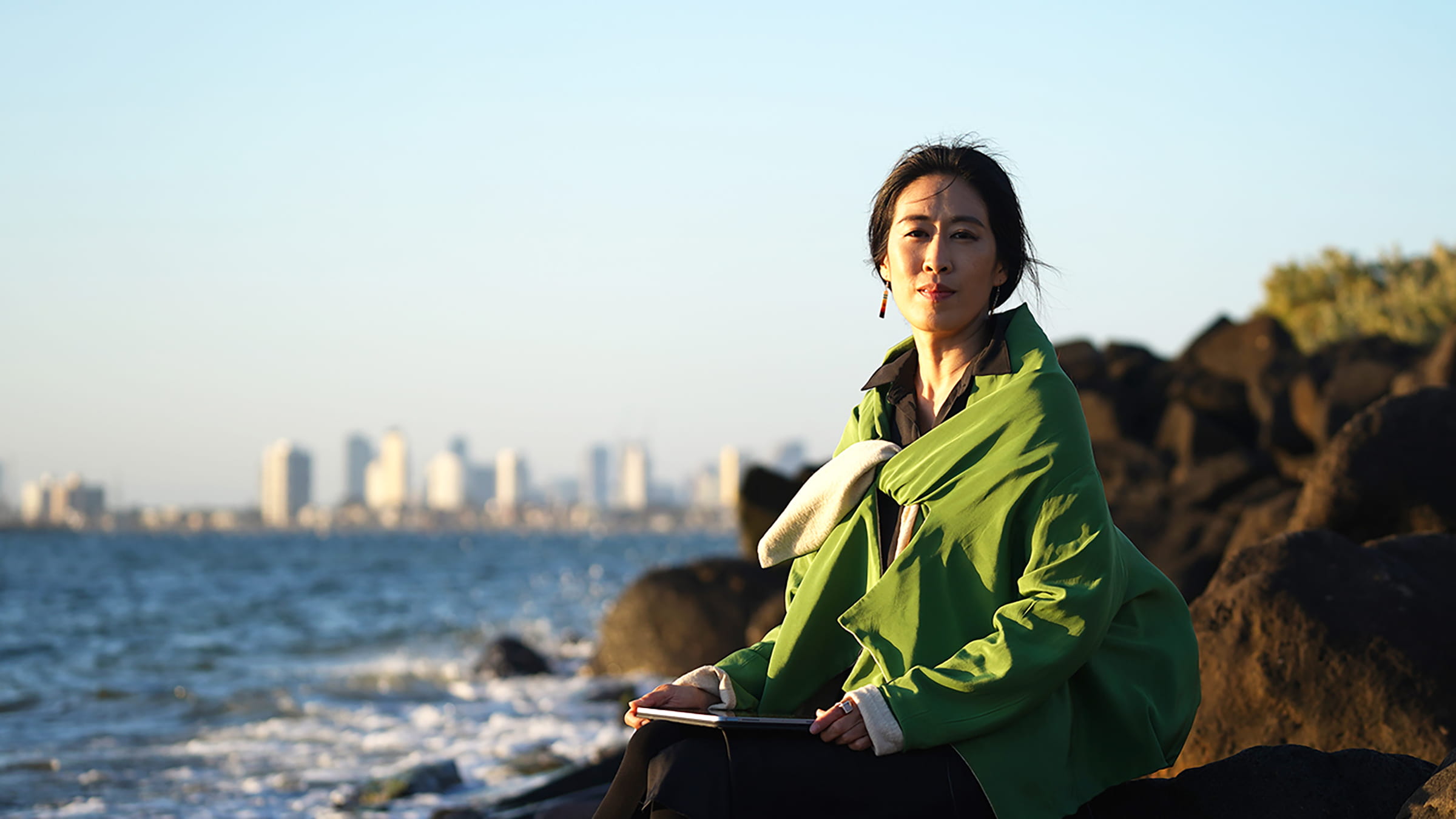 Portrait of Sunny Kim on the rocks in Sydney on a sunny late afternoon with the ocean and city in the background